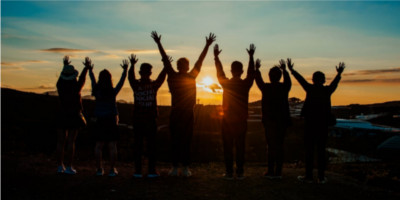 Silhouetted people with raised arms